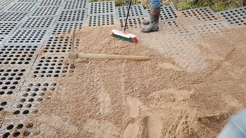 Sweeping sand into mud grid panels