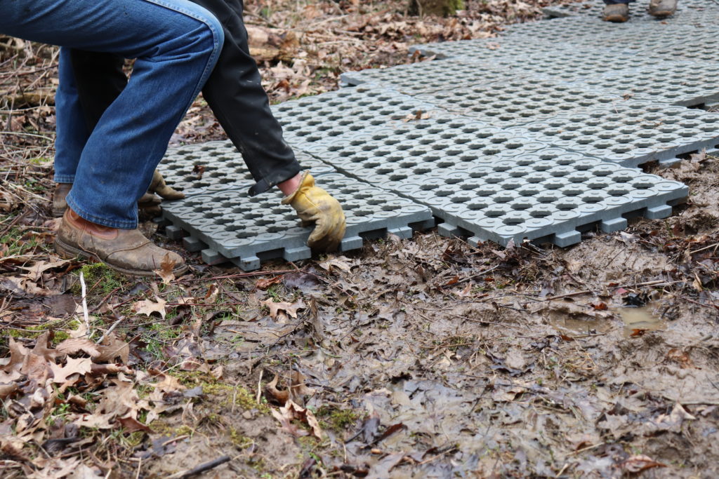 mud grids being laid overtop of a muddy horse trail